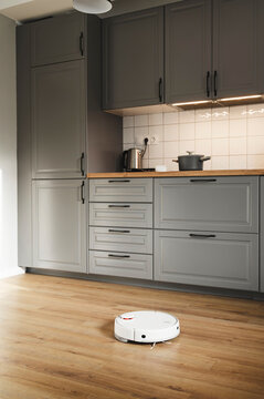 Robot vacuum cleaner cleaning kitchen at home
