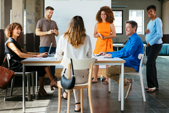 Happy business colleagues having discussion in meeting at office