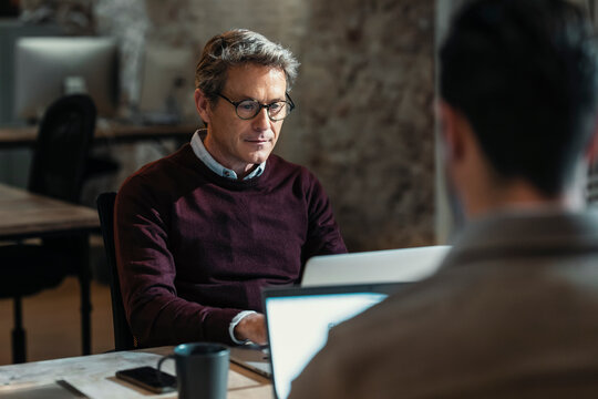 Architect father looking at document with son at office