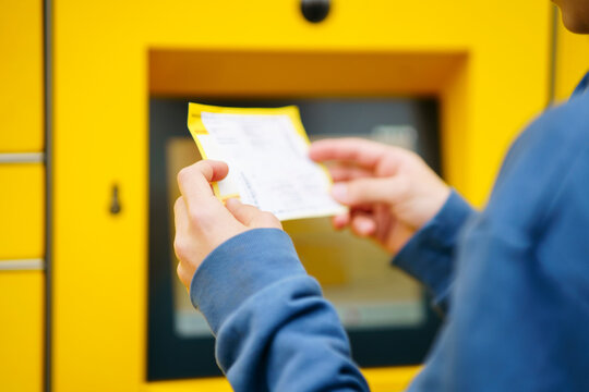 Boy holding ticket in front of parcel locker