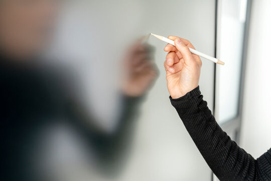 Hand of businesswoman writing on interactive whiteboard with digitized pen