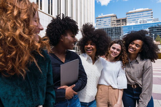 Happy young businesswomen together spending time in office park