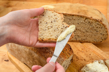 Kromka świeżego chleba smarowana masłem  - obrazy, fototapety, plakaty