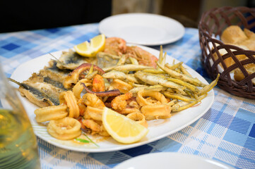 A mixed sea food plate on a blue and white table.
