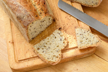 Kroić chleb na desce kuchennej w kuchni - obrazy, fototapety, plakaty