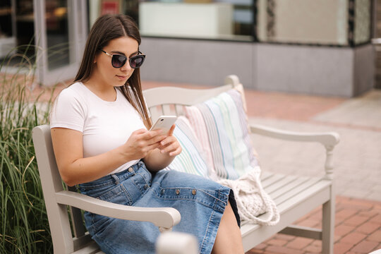 Side view of female ssm manager configures the target on her phone. Woman working outdoors