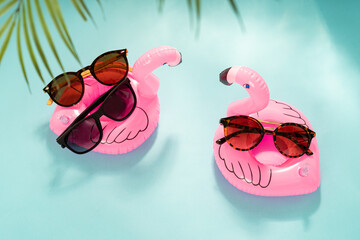 Sunglasses sale. Summer sale-out offer. Trendy sunglasses in plastic frame on inflatable flamingo...