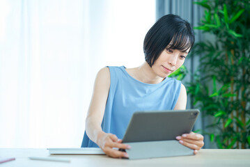 不安な表情でパソコンを触る女性