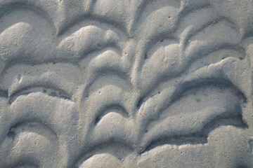 Structure in the sand made by waves. View on the ground at low tide. Nature photo