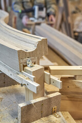 Bending wooden staircase handrail made of oak planks and plywood on table closeup. Detail of stairs...