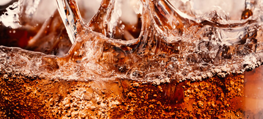 Splashing of Cola and Ice. Cola soda and ice splashing fizzing or floating up to top of surface....