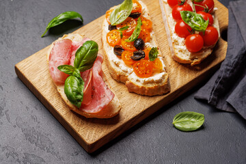 Sandwich set of bruschetta with juicy tomatoes, cheese and prosciutto