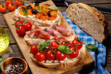 Sandwich set of bruschetta with juicy tomatoes, cheese and prosciutto