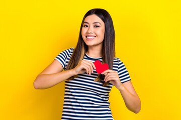 Photo of young cute chinese lady hold red paper postcard heart gift love story valentine day holiday isolated on yellow color background