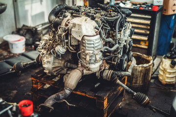 disassemble the engine from the car in the car workshop.