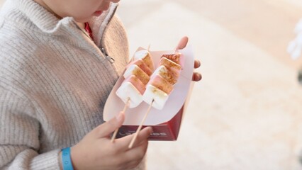 A child takes a toasted marshmallow from the hands of a salesman