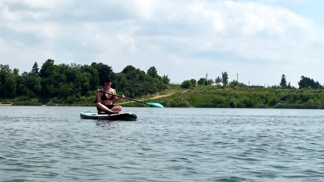 woman on supboard swimming on lake