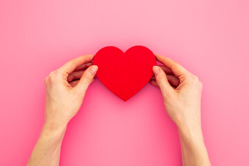 Red heart with woman hands, top view. Health care and love concept