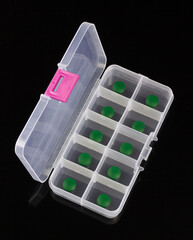 box with green pills isolated on black background, box for tablets, box for vitamins