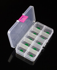box with green pills isolated on black background, box for tablets, box for vitamins