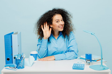 Young fun successful employee business woman wear casual shirt sit work at white office desk try to...