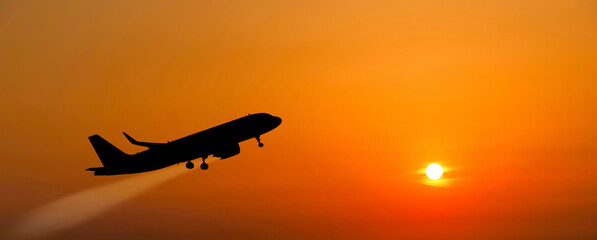 The plane takes off at sunset.