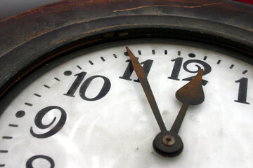 Uhr mit altem Ziffernblatt zeigt 5 vor 12