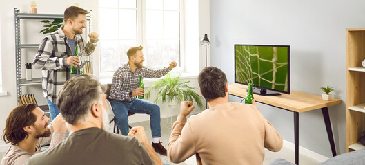 Men watching football on TV. Male friends spending free time together, sitting on sofa at home,...