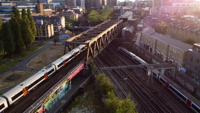 Drone shot overground train travelling through Shoreditch in London