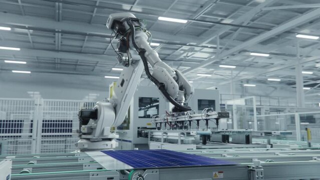 Automated Solar Panel Production Line. White Industrial Robot Arm Assembles Solar Panel, Placing PV Cells. Modern, Bright Manufacturing Facility.