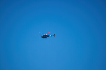 Blue helicopter flying in clear sky