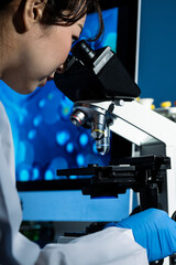 Close-up of a scientist looking at a specimen under a microscope