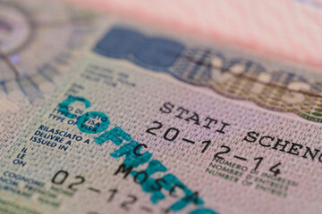 close-up part of page of document, foreign passport for travel with European visa, tourist schengen visa stamp with hologram with shallow depth of field, passport control at border, travel in Europe