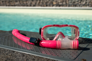 diving goggles with snorkel in front of a swimming pool