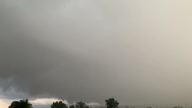 Rainy stormy clouds and Arcus cloud, Roll clouds,  Shelf clouds - menacing thundercloud moving over trees horizon of Silesian Beskid mountains in Poland in stormy summer day. 