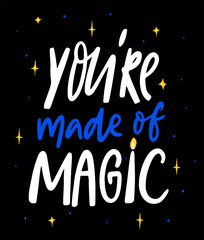 You are made of magic. Inspirational witchy quote, hand lettering on black background decorated with magic elements.