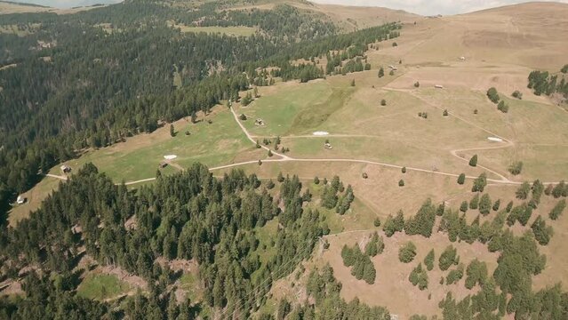 Thrilling FPV drone footage captures close flybys between trees and wooden huts above Luzen village's hills. Immersive and captivating aerial view. LuPa Creative.