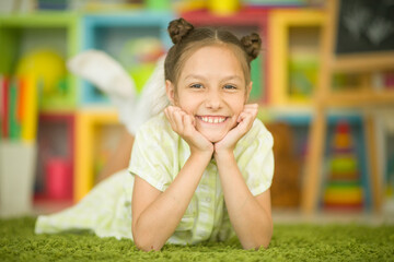 Girl lying on cozy carpet at home. 