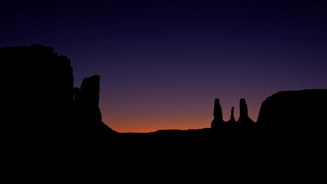 Three sisters in Monument Valley on sunset - Spectacular rock formations at night with desert landscapes - American West National Parks sighseeing detours
