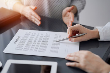 Business people discussing contract signing deal while sitting at the glass table in office, closeup. Partners or lawyers working together at meeting. Teamwork, partnership, success concept