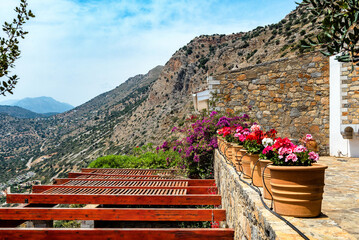 Terrace adorned with ceramic pots brimming with a vibrant array of colorful flowers, all against the backdrop of a majestic mountain view. 