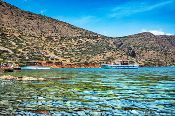 Fototapeta premium The sparkling azure waters merge seamlessly with the clear blue sky, creating a harmonious and captivating scene. Solitary boat gracefully adorning the horizon. 