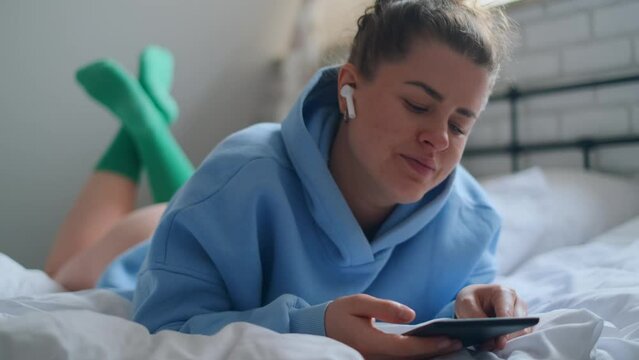 Woman reads e-book and listens to instrumental music in her cozy apartment, 4k