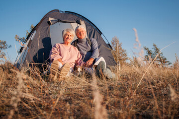 Camping tent vacation Senior couple man and woman sitting near camp tent