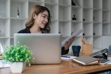 Asian businesswoman sit at their desks and calculate financial graphs showing results about their investments, plan a successful business growth process