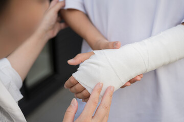 骨折や打撲、捻挫をして腕を固定するイメージのアップ　心配する