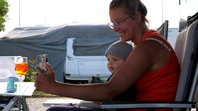 Mother and baby making phone call facetime with grandparents during holiday, close up slow motion