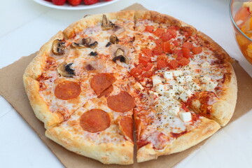Pizza with mushrooms, sausage and olives on a wooden background