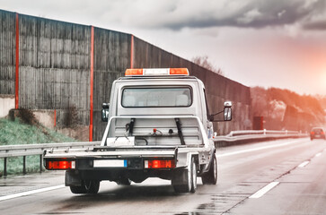 Empty flatbed tow carrier truck. empty car carrier and flatbed tow truck vehicle travelling on a...