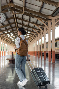 Woman traveler tourist walking with luggage at train station. travel lifestyle concept